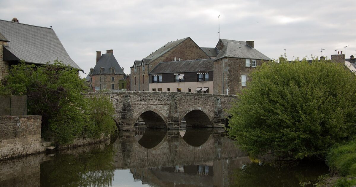 Le vieux pont de 1613 sur la Sélune, à Ducey, avec le château en arrière-plan
